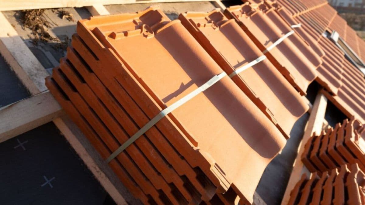 Keramische dakpannen op een dak tijdens de plaatsing, klaar voor installatie.