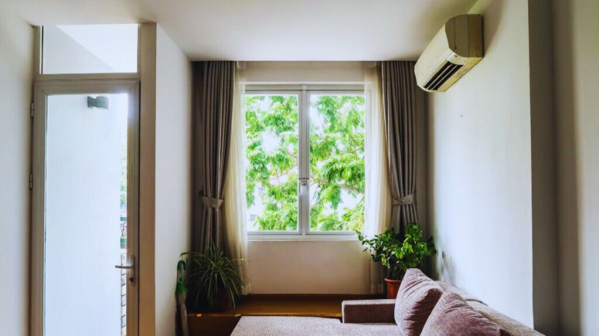 Interieur van een woonkamer met een airco aan de muur, typisch voorbeeld van toestellen van de beste airco merken voor huishoudelijk gebruik.